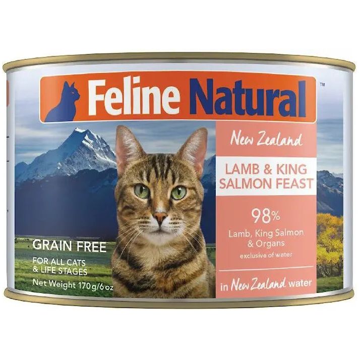 A can of Feline Natural Lamb & King Salmon Feast Grain-Free Canned Cat Food features a tabby cat before mountains; the label highlights 98% meat content—ideal nutrition for all cats.
