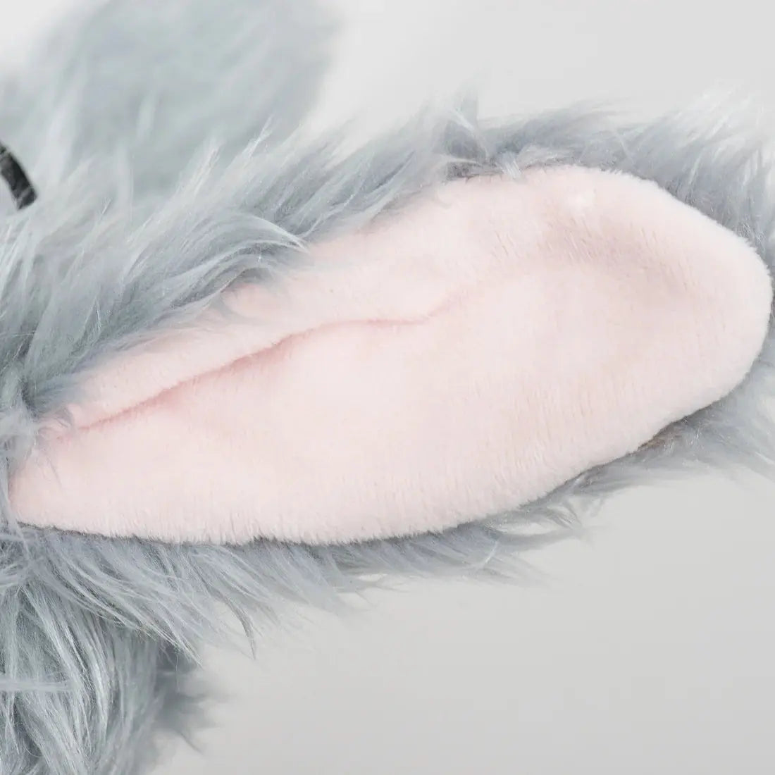 Close-up of a soft, plush gray ear with light pink lining from the HuggleHounds Birch Bunny X-Brace Tough Squeaky Plush Dog Toy, shown against a plain background.