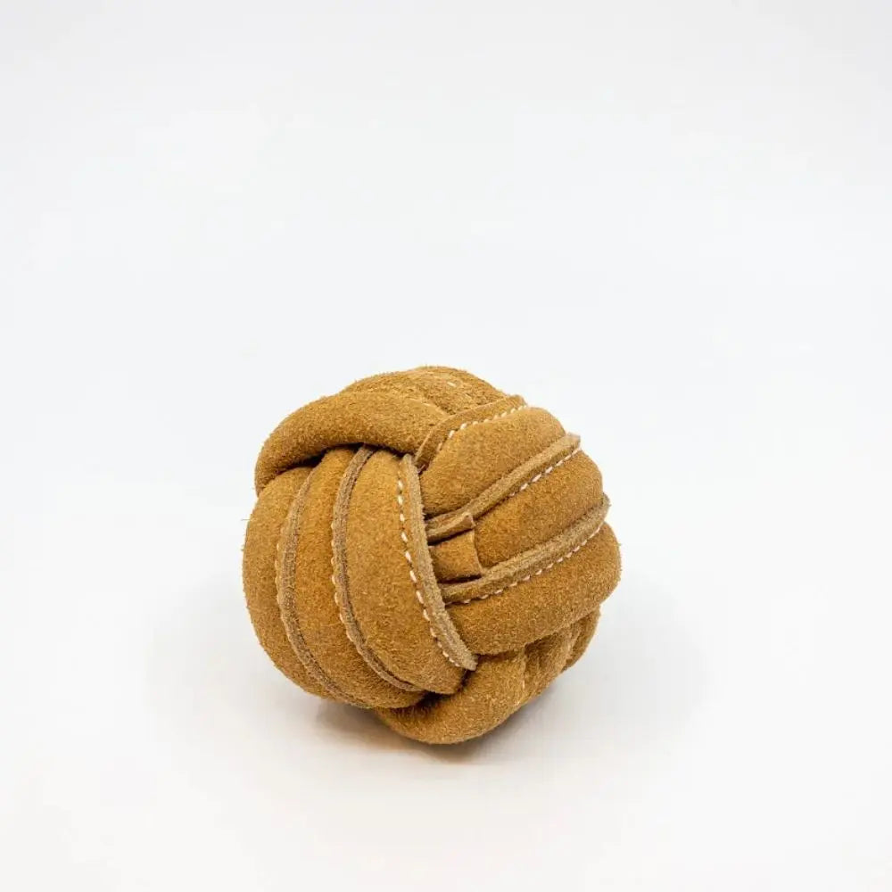 The HuggleHounds HuggleHide Natural Leather Ball Dog Toy, crafted from tan suede leather with visible stitching, sits on a white background—a durable and stylish chew toy for your pup.
