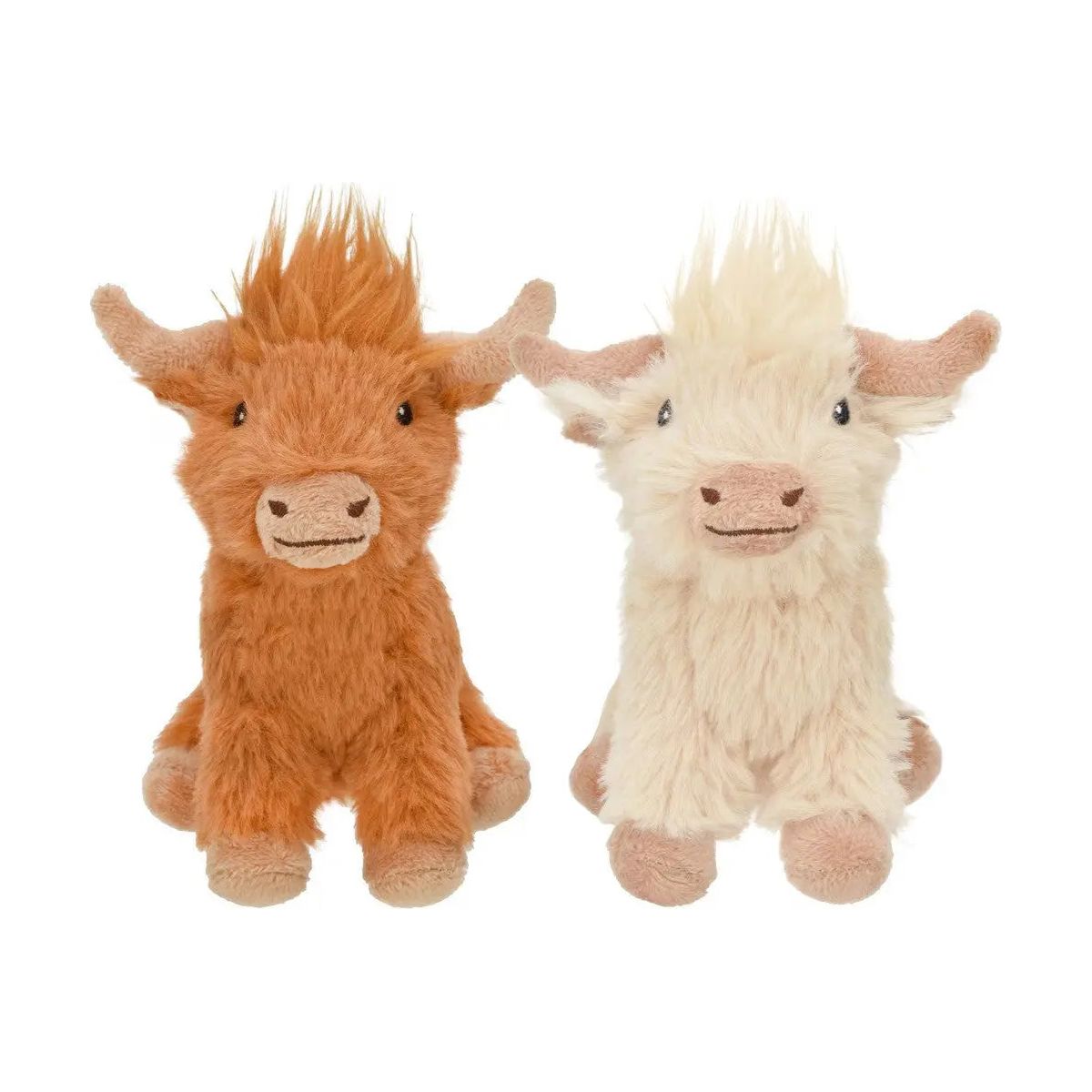 Two Multipet Highland Cow Dog Toys are side by side: the left toy is light brown with fur tufts, and the right one is cream-colored with fluffy fur. Both plush companions feature small horns and soft expressions.