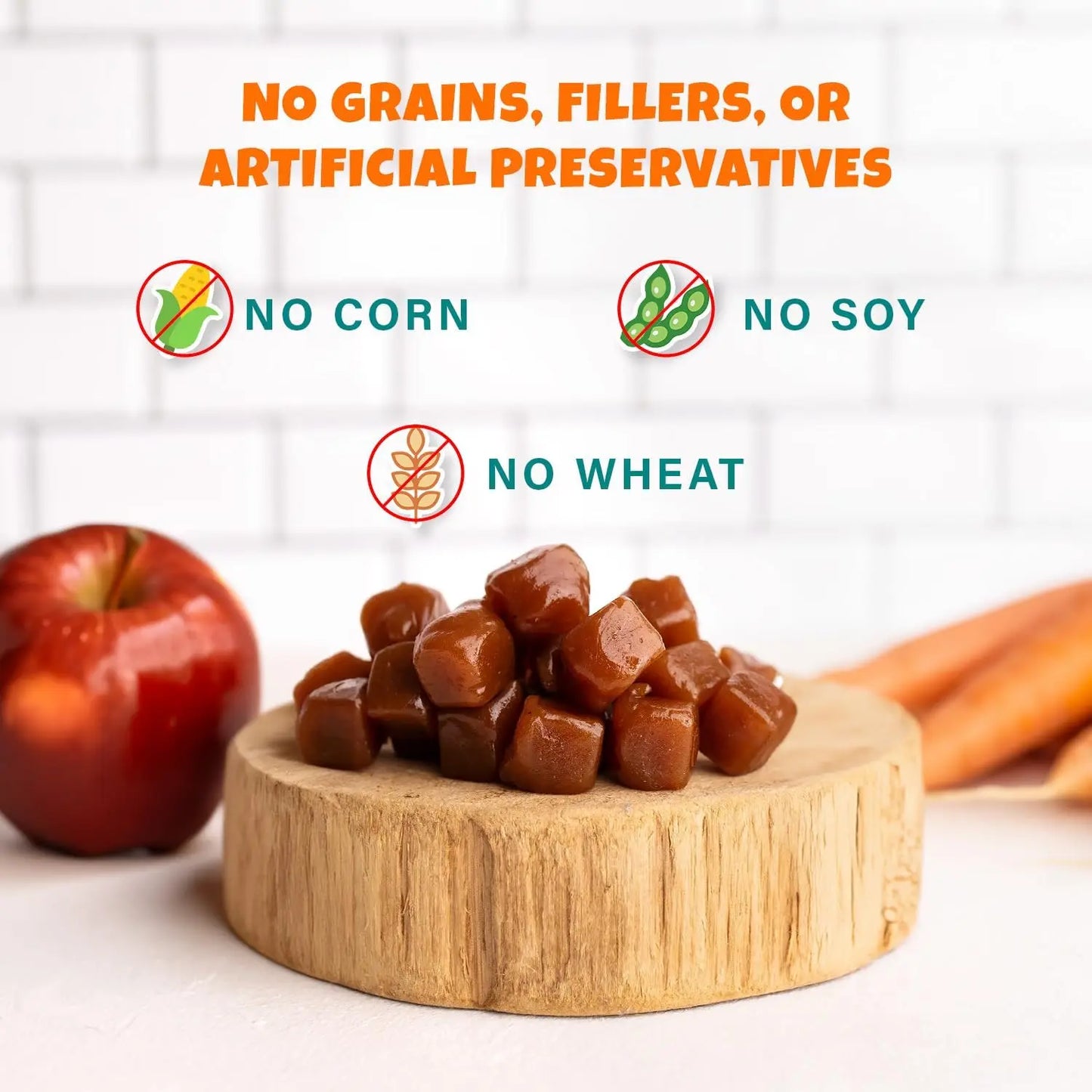 PETIPET Apples + Carrots Bites Soft & Chewy Dog Treats (5 oz) from PETIPET are plant-based, grain-free snacks with no fillers or artificial preservatives. Shown on a wooden board with apple and carrots in the background.