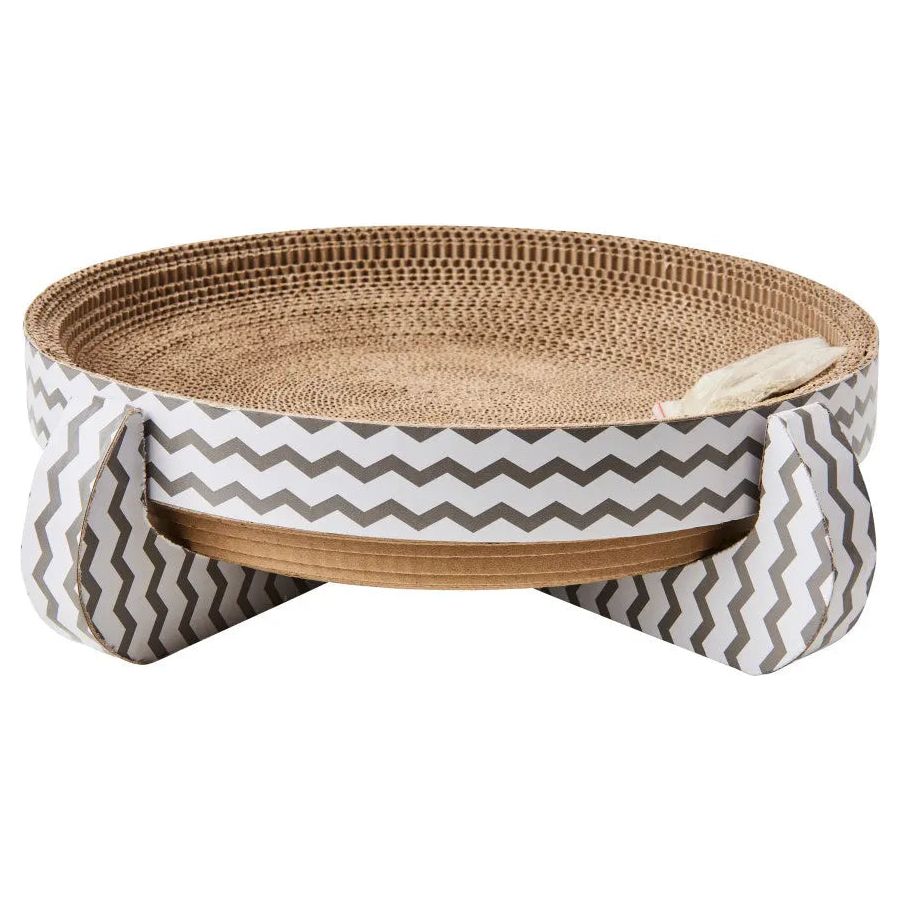 The Spot Nest Cat Scratcher by Spot features corrugated cardboard with gray and white zigzag-patterned sides and legs. Elevated and round, it promotes nail health and includes a small white toy mouse on the scratcher surface.