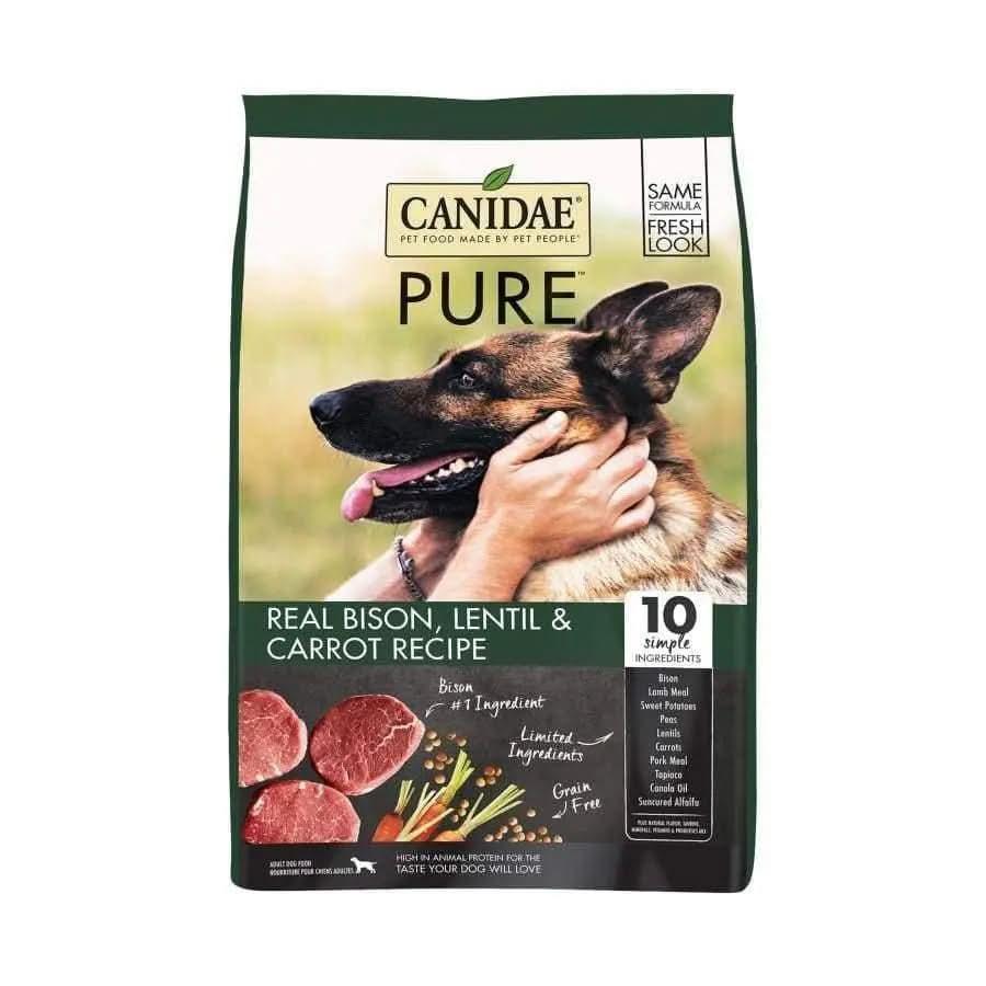 A bag of CANIDAE PURE Grain-Free Real Bison, Lentil & Carrot Recipe Dry Dog Food features a German Shepherd being petted, with images of bison, lentils, and carrots. Highlights 10 simple ingredients.