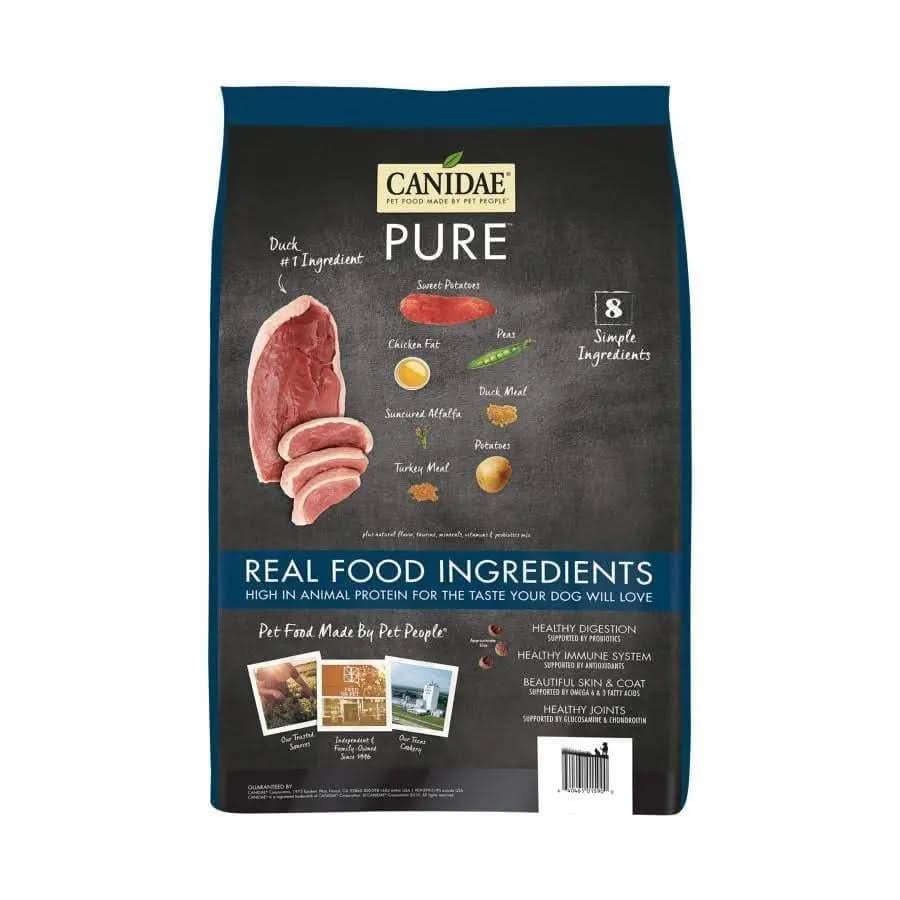 A bag of CANIDAE PURE Grain-Free Real Duck & Sweet Potato Recipe dry dog food shows images of duck and sweet potatoes, featuring “Real Food Ingredients” and “8 Simple Ingredients” on a black background for limited ingredient diets.