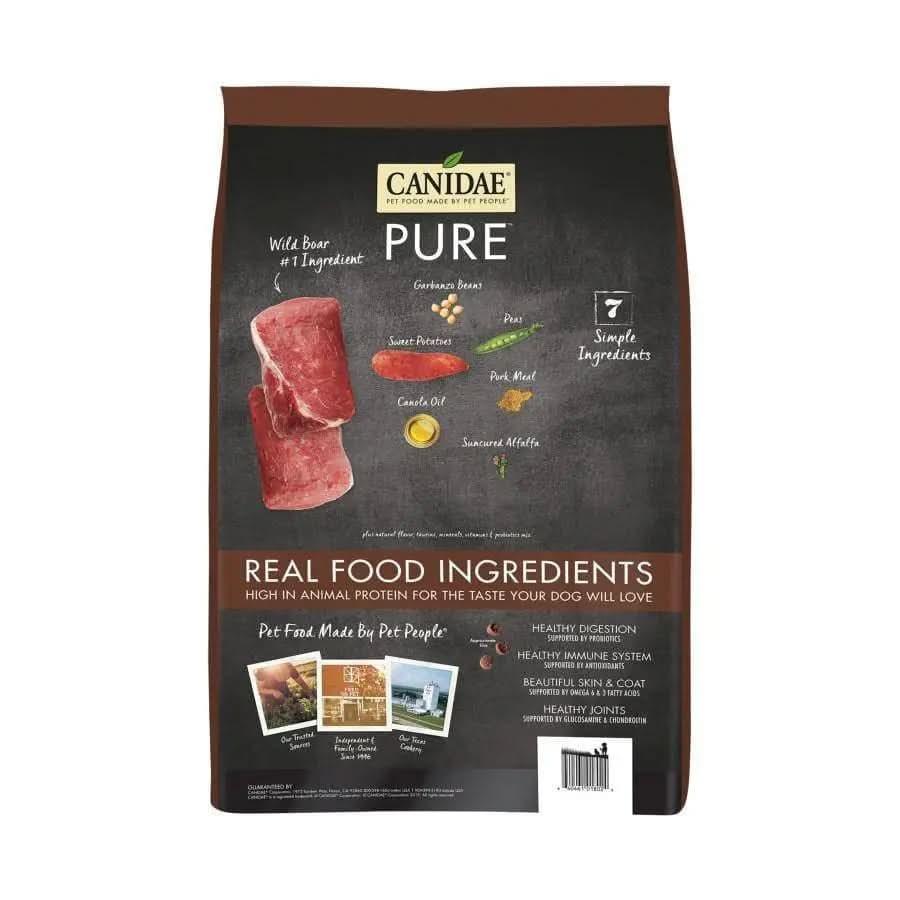 A bag of CANIDAE PURE Grain-Free Real Wild Boar & Garbanzo Bean Recipe Top Dry Dog Food features 7 simple ingredients and real food benefits for sensitive dogs, shown in a brown, black, and yellow design with images of wild boar and garbanzo beans.