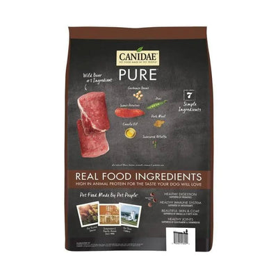 A bag of CANIDAE PURE Grain-Free Real Wild Boar & Garbanzo Bean Recipe Top Dry Dog Food features 7 simple ingredients and real food benefits for sensitive dogs, shown in a brown, black, and yellow design with images of wild boar and garbanzo beans.