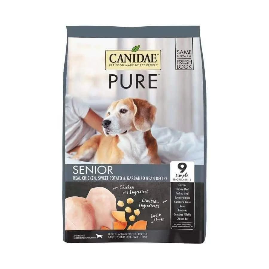 A bag of CANIDAE PURE Grain-Free Senior Real Chicken Sweet Potato & Garbanzo Bean Recipe Dry Dog Food features a dog on a bed and highlights its grain-free, limited ingredient formula with chicken, sweet potato, and garbanzo beans.
