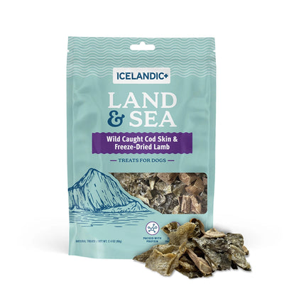 The Icelandic+ Land & Sea Cod Skin & Freeze-Dried Lamb Dog Treat 2.4 oz features wild-caught cod skin and freeze-dried lamb in blue-green packaging with a mountain design, treat window, and visible treats displayed in front.