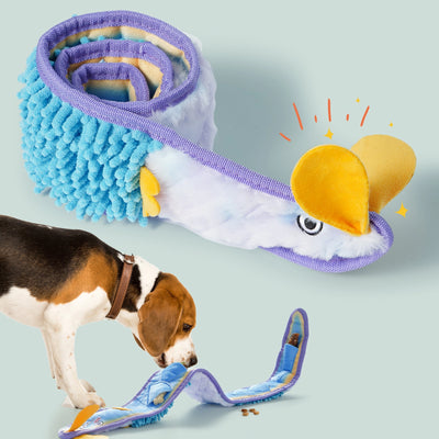 A beagle explores the Nocciola Interactive No-Stuffing Eel Toy—an eel-shaped blue, white, and yellow plush by Nocciola with treat pockets for mental stimulation, shown coiled and unrolled on a pale background.