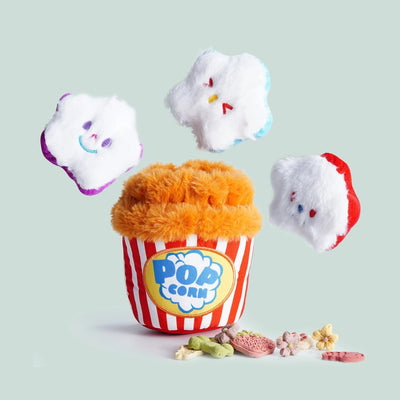 The Nocciola Interactive Popcorn Bucket Dog Toy features squeaky plush popcorn pieces with smiling faces, plus fun flower and bone-shaped treats, offering mental stimulation for dogs.