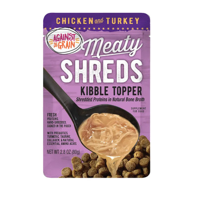 Against the Grain Shreds Kibble Topper Chicken & Turkey in Bone Broth is shown poured over dry kibble, with its purple and gold pouch displaying product details and a tasty serving suggestion. 24/2.8oz.