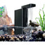 A small turtle sits on rocks in an aquarium with the AquaTop Aquatop Terratop Aquatic Reptile Tank Filter Clean Water and Healthier Pets, surrounded by pebbles, green plants, and a rocky backdrop—ideal for terrariums and paludariums.