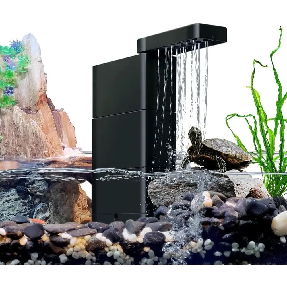 A small turtle sits on rocks in an aquarium with the AquaTop Aquatop Terratop Aquatic Reptile Tank Filter Clean Water and Healthier Pets, surrounded by pebbles, green plants, and a rocky backdrop—ideal for terrariums and paludariums.