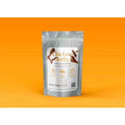 A silver resealable pouch labeled Bonapet All-Natural Chicken Jerky for Healthy Pets 5 oz sits on an orange background, featuring chicken graphics, product details, and the Bonapet Treat brand name emphasizing high-quality protein for pets.