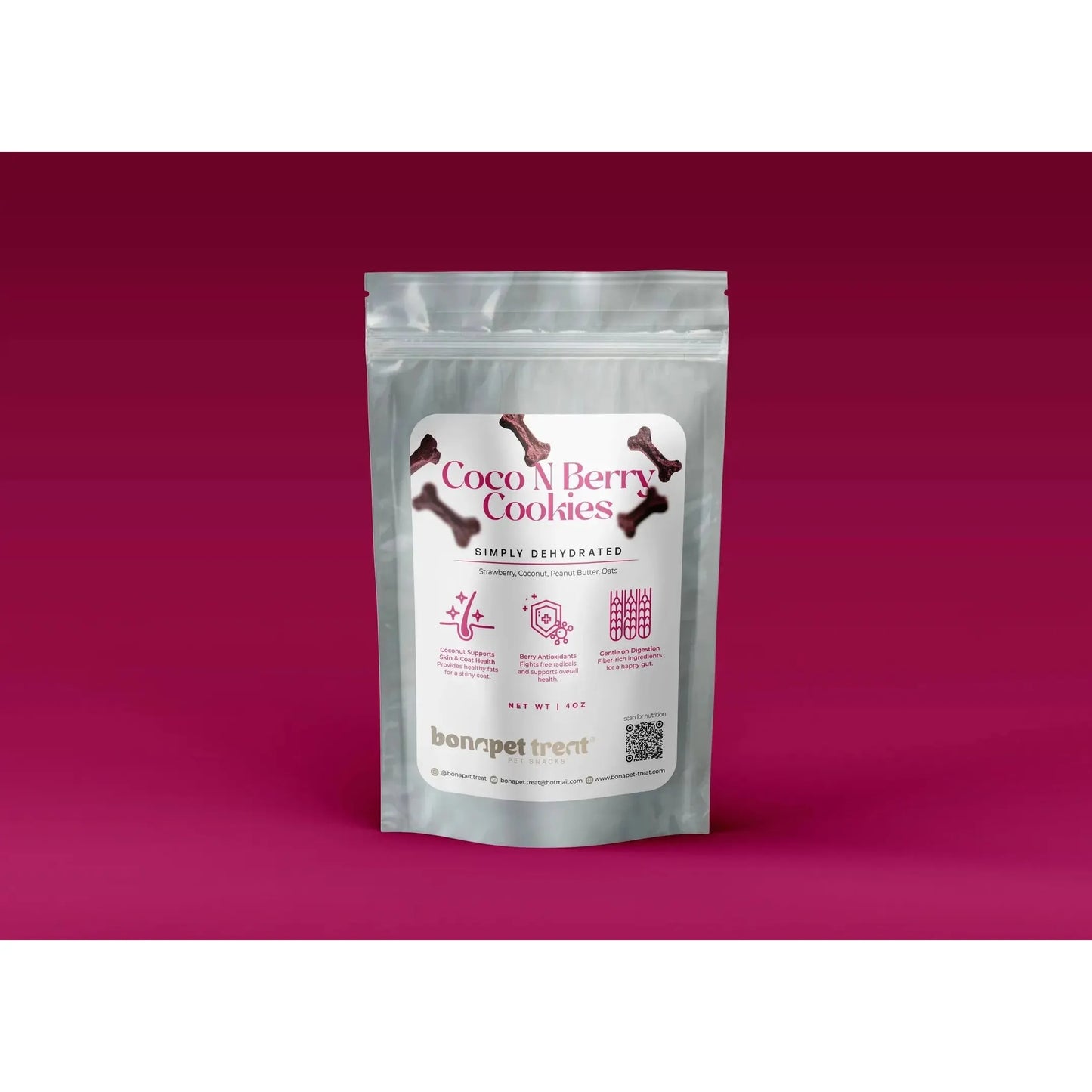 A silver resealable pouch labeled Bonapet Coco N Berry Organic Dog Cookies 4 oz from Bonapet Treat, featuring bone graphics, icons, and details about its antioxidant-rich, peanut butter recipe rests on a dark pink gradient background.