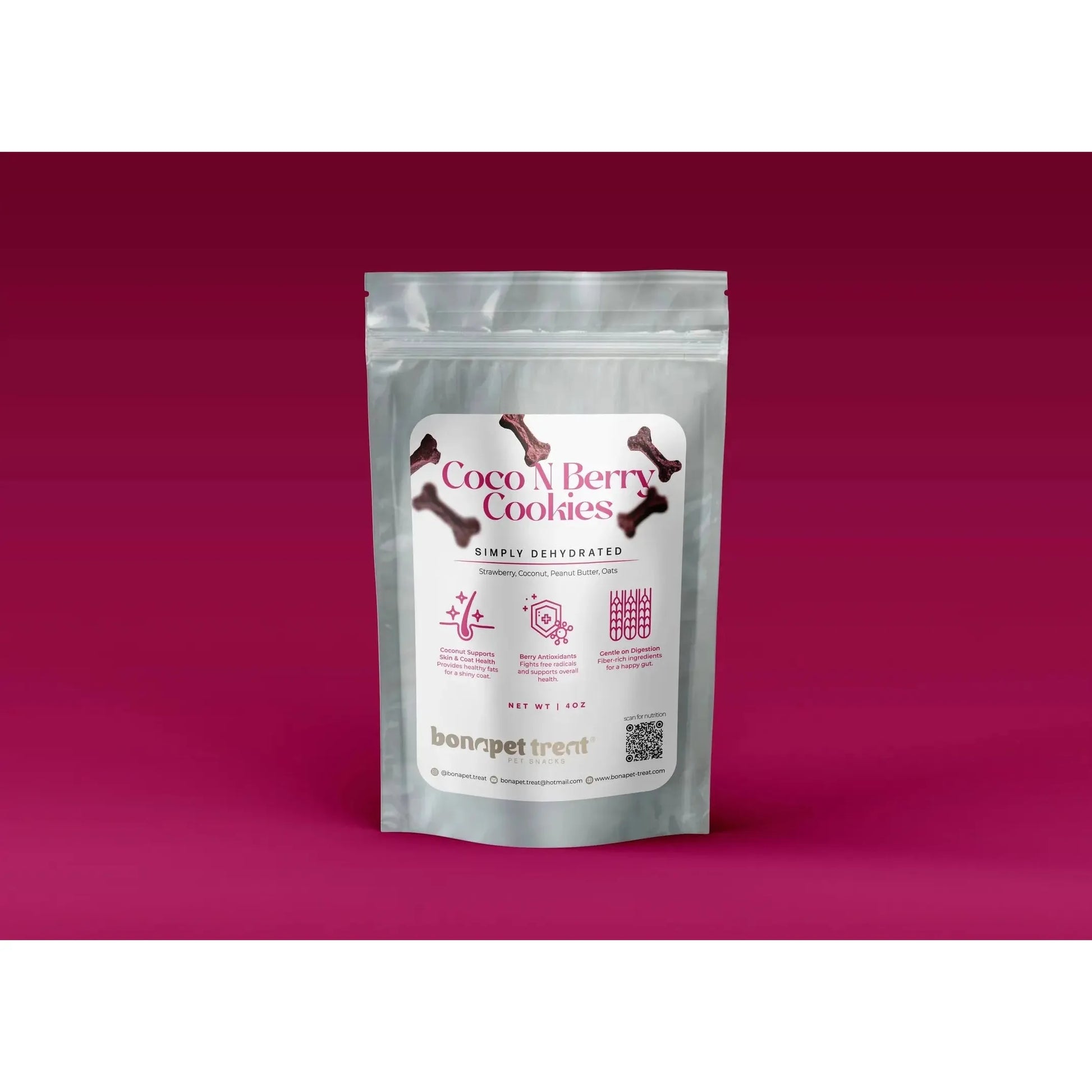 A silver resealable pouch labeled Bonapet Coco N Berry Organic Dog Cookies 4 oz from Bonapet Treat, featuring bone graphics, icons, and details about its antioxidant-rich, peanut butter recipe rests on a dark pink gradient background.