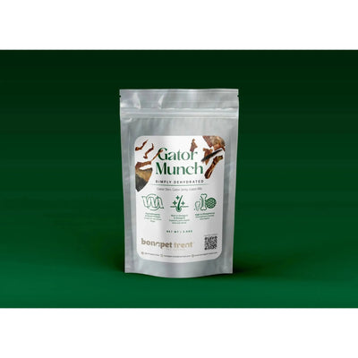 A silver resealable pouch labeled Bonapet Gator Munch: Hypoallergenic, All-Natural Dog Treats 4 oz by Bonapet Treat stands upright against a green background, showing images of all-natural dog treats and product details on the front.