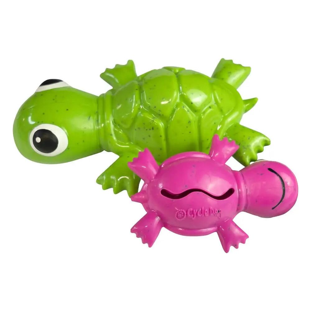 A Cycle Dog 3-Play Turtle Dog Toy in green, made from eco-friendly materials, sits beside a pink plastic crab with a smiling face—both durable pet toys from Cycle Dog.