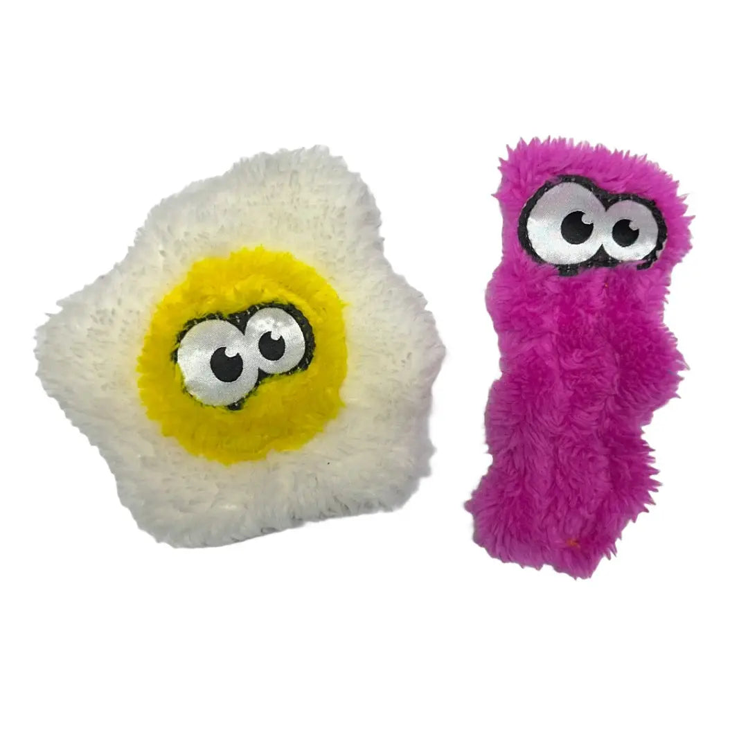 Two Cycle Dog Duraplush Cat Toys: one plush fried egg and one long, wavy pink toy, both with large embroidered cartoon eyes. Durable and fun, these cat toys are from Cycle Dog.