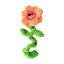 The Cycle Dog Duraplush Unstuffed Springyflowers Dog Toy by Cycle Dog is shaped like an orange flower with a pink center, cartoon eyes, twisted green stem, and two leaves, shown on a white background.