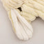 Close-up of a cream-colored HuggleHounds Woodland HuggleFlatties Tough Squeaky Plush Small Dog Toy with ribbed fabric and long floppy ears, from the 3-pack set, lying on a light surface.