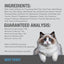A fluffy white and gray cat with blue eyes sits in front of a Feline Natural Beef Feast Grain-Free Canned Cat Food label featuring wholefood ingredients and guaranteed analysis, set against a blue-gray background.