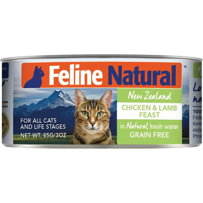 A can of Feline Natural Chicken & Lamb Feast Grain-Free Canned Cat Food, showing a tabby cat before mountains. The label highlights cage-free chicken and grass-fed lamb from New Zealand for cats of all life stages.