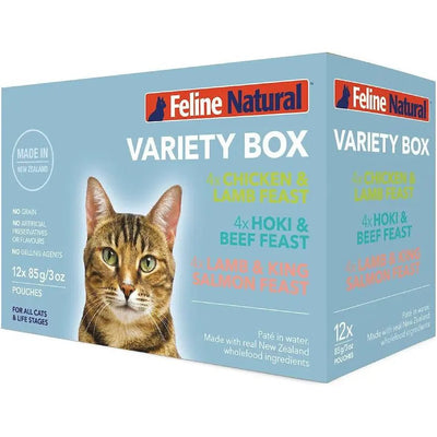 A box of Feline Natural Feast Grain-Free Wet Cat Food Pouch 12/3oz displays a close-up of a tabby cat. The pack includes cage-free chicken and free-range lamb flavors. Blue background highlights key product details.