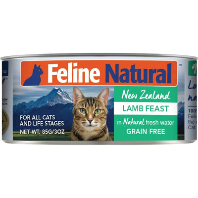 A can of Feline Natural Lamb Feast Grain-Free Canned Cat Food, featuring a brown tabby cat before mountains. The label highlights grain-free, premium quality made with fresh water for all cats and life stages by Feline Natural.