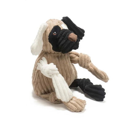 The HuggleHounds Huggle Mutts Patches the Mutt Tough Squeaky Plush Dog Toy features ribbed beige, black, and white fabric, floppy ears, and knotted limbs. This durable toy is shown sitting upright against a white background.