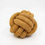 The HuggleHounds HuggleHide Natural Leather Ball Dog Toy is a durable, textured chew toy in light brown, featuring a cozy, interwoven design—perfect for dogs who love to chew. Brand: HuggleHounds.