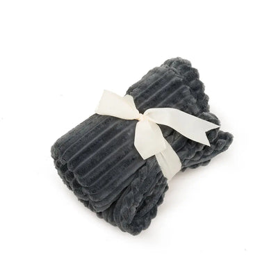 The HuggleHounds Scout Blankie Double-Sided Plush Dog Blanket by HuggleHounds is shown folded and tied with a white ribbon, in dark gray ribbed plush, displayed on a white background.