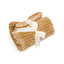 The HuggleHounds Scout Blankie Double-Sided Plush Dog Blanket by HuggleHounds, shown folded and ribbed in light brown, is tied with a cream ribbon in a bow and displayed on a white background.