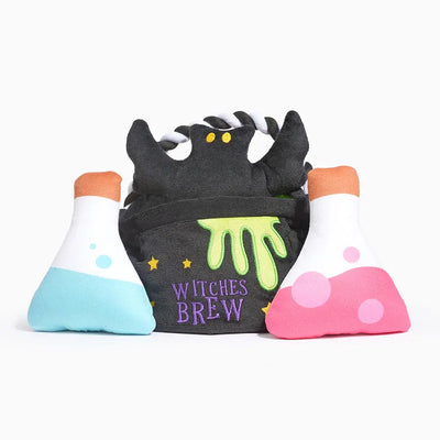 The Hugsmart Pet Howloween Night Witches Brew Interactive Dog Toy set features a black cauldron with green slime and “Witches Brew” in purple, flanked by blue and pink potion bottles—perfect for spooky Halloween play.