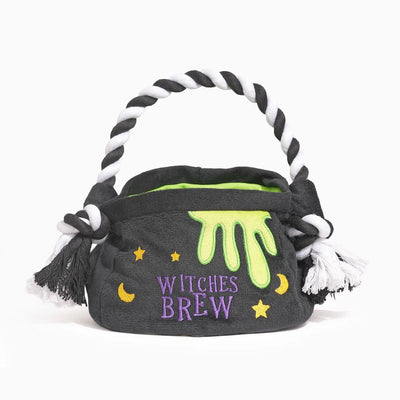 The Hugsmart Pet Howloween Night Witches Brew Interactive Dog Toy features a plush black basket with a white and black twisted handle, yellow stars, crescent moons, green slime, and WITCHES BREW embroidered in purple on the front.