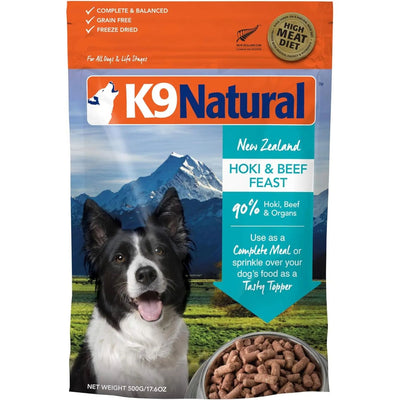 K9 Natural Hoki & Beef Grain-Free Freeze-Dried Dog Food features a happy black and white dog, a bowl of food, snowy mountains, and emphasizes a high-meat diet with sustainably sourced ingredients.