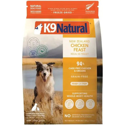 A bag of K9 Natural New Zealand Chicken Feast Grain-Free Freeze-Dried Dog Food shows a happy dog outdoors with mountains and a lake, highlighting 94% cage-free chicken & organs, grain-free recipe, and freeze-dried natural goodness.