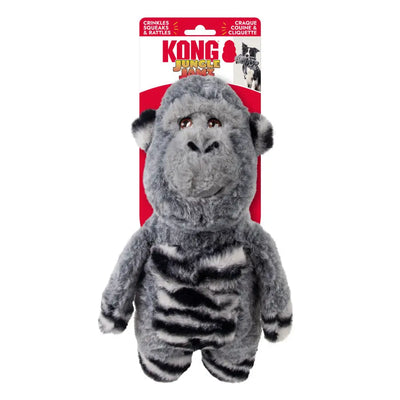 The KONG Jungle Jamz Gorilla Dog Toy by Kong is gray and black with a fluffy texture, brown embroidered eyes, a smiling face, and a durable squeaker, shown in front of red and white KONG Jungle Jamz packaging.