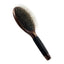 The Kenchii Metal Pin Brush Oval by Kenchii features a dark maple wood handle, non-slip grip, and a black oval base with metal bristles finished with round tips.