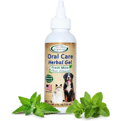 A bottle of Mad About Organics Herbal Gel for Pet Oral Care by Mad About Organics, labeled Fresh Mint, features images of a cat and dog on the front. Fresh mint leaves beside the bottle emphasize its natural ingredients.