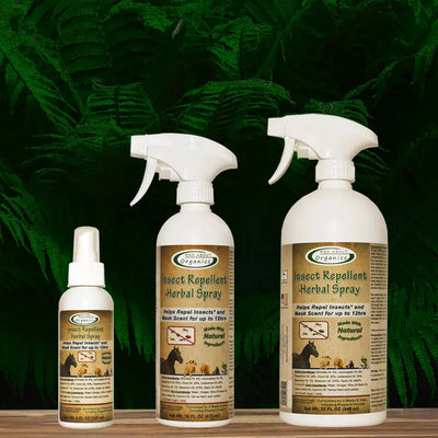 Three bottles of Mad About Organics Herbal Spray – Natural Bug Repellent for Pets are displayed on wood with a green leafy background, showcasing natural bug protection. The labels note it’s made in the USA by Mad About Organics.