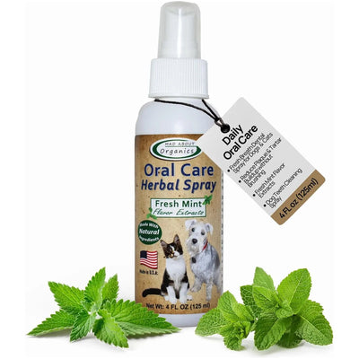 A 4 fl oz bottle of Mad About Organics Oral Care Spray - Fresh Mint Formula for pets features a cat and dog on the label, mint leaves in front, and a tag promoting its effectiveness as a plaque and tartar remover.