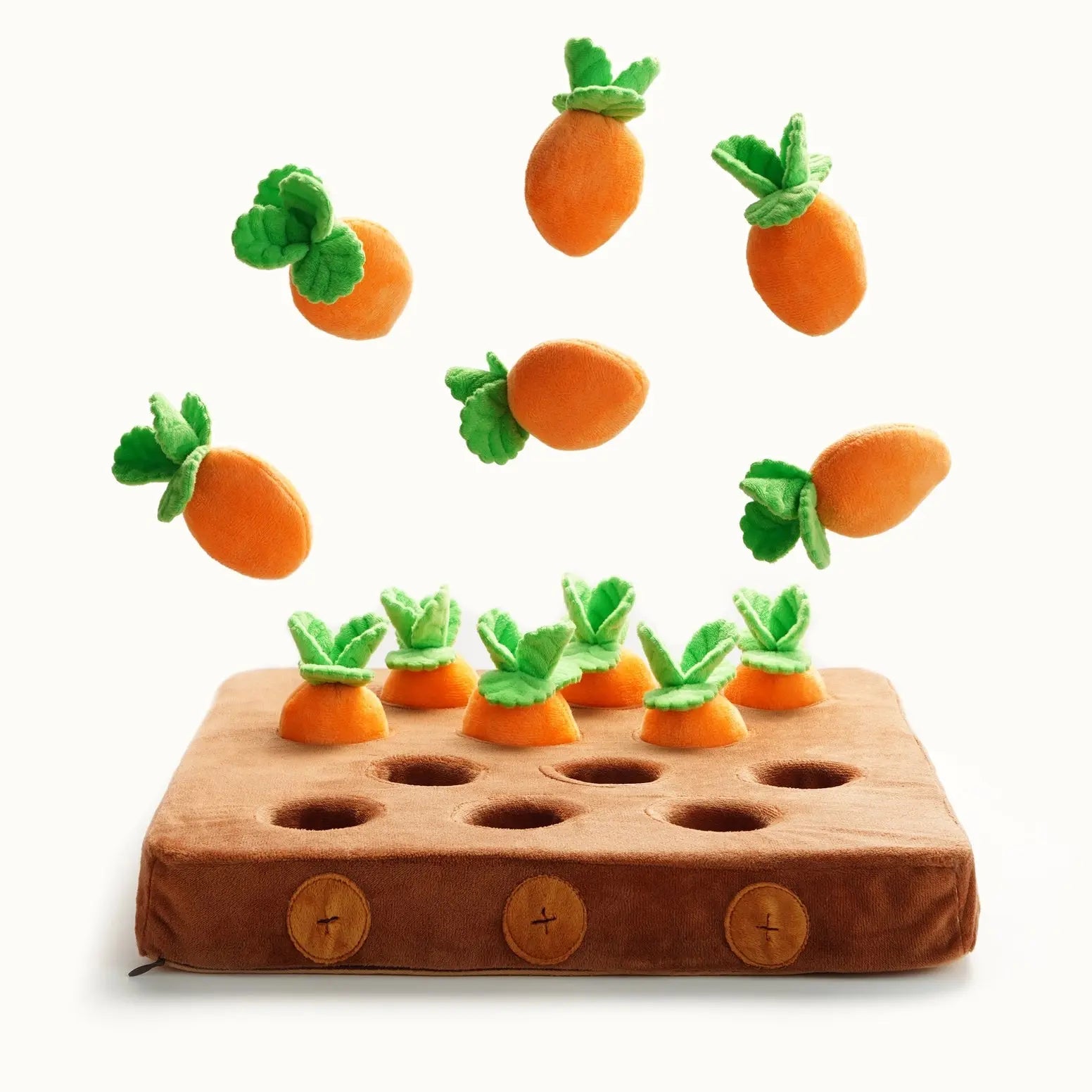 The Nocciola Hide & Chew Carrot Enrichment Toy by Nocciola is a plush brown interactive dog toy with nine holes, filled with soft orange carrots. Seven extra carrots float above it against a white background for added fun.