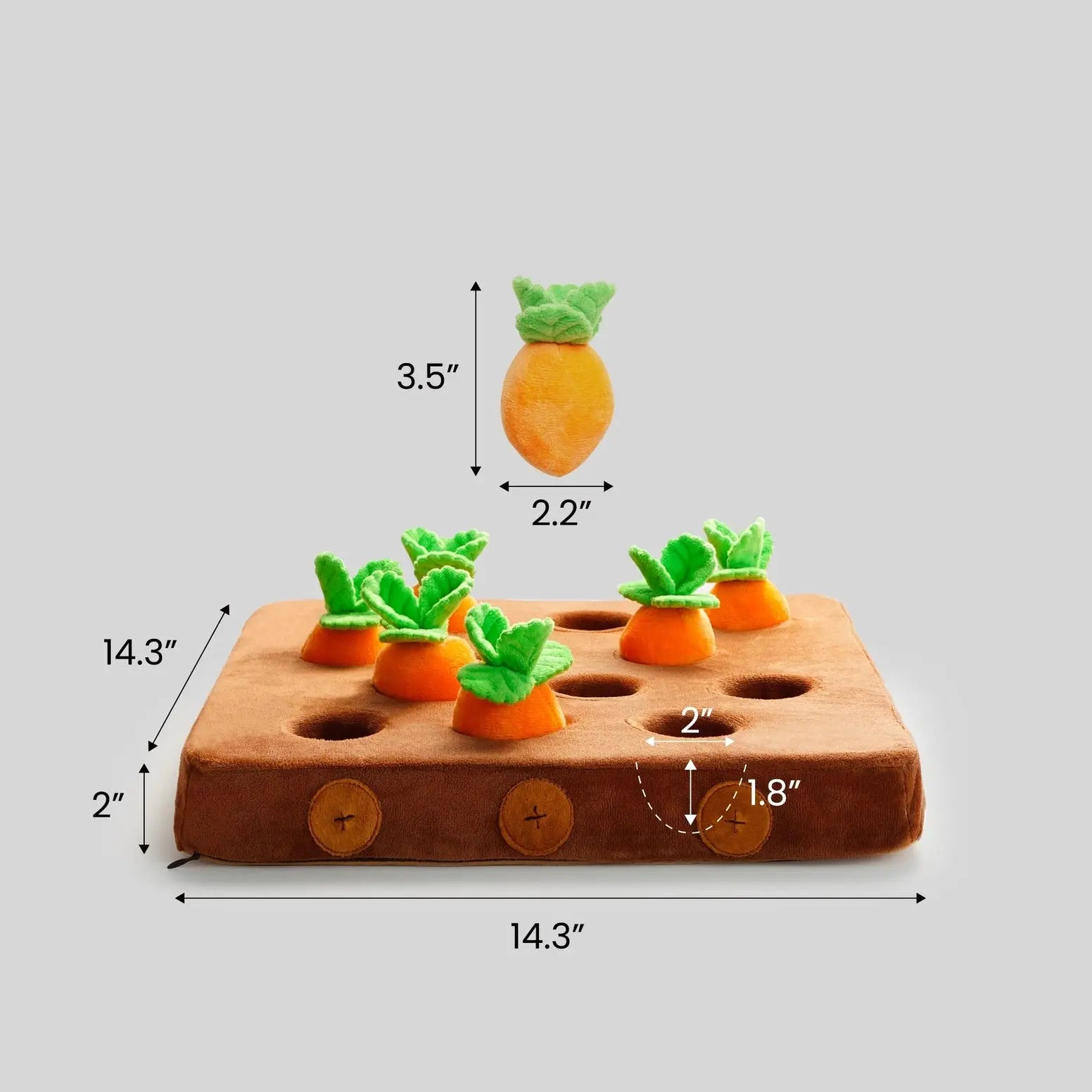 The Nocciola Hide & Chew Carrot Enrichment Toy features plush carrots (3.5x2.2) with green leaves that fit into 2 holes on a 14.3x14.3x2 soft brown mat, providing mental stimulation for dogs, all on a light gray background.
