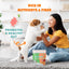 A woman smiles as she feeds a small white and brown dog standing on its hind legs. Text highlights gut health benefits, with a PETIPET Apples + Carrots Bites Soft & Chewy Dog Treats 5 oz package featuring plant-based ingredients in view.