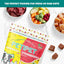 A 5 oz package of PETIPET Bananas + Strawberries Bites Soft & Chewy Dog Treats sits on a white surface, surrounded by bowls of raw meat and veggies—a perfect organic treat to pair with fresh or raw diets.