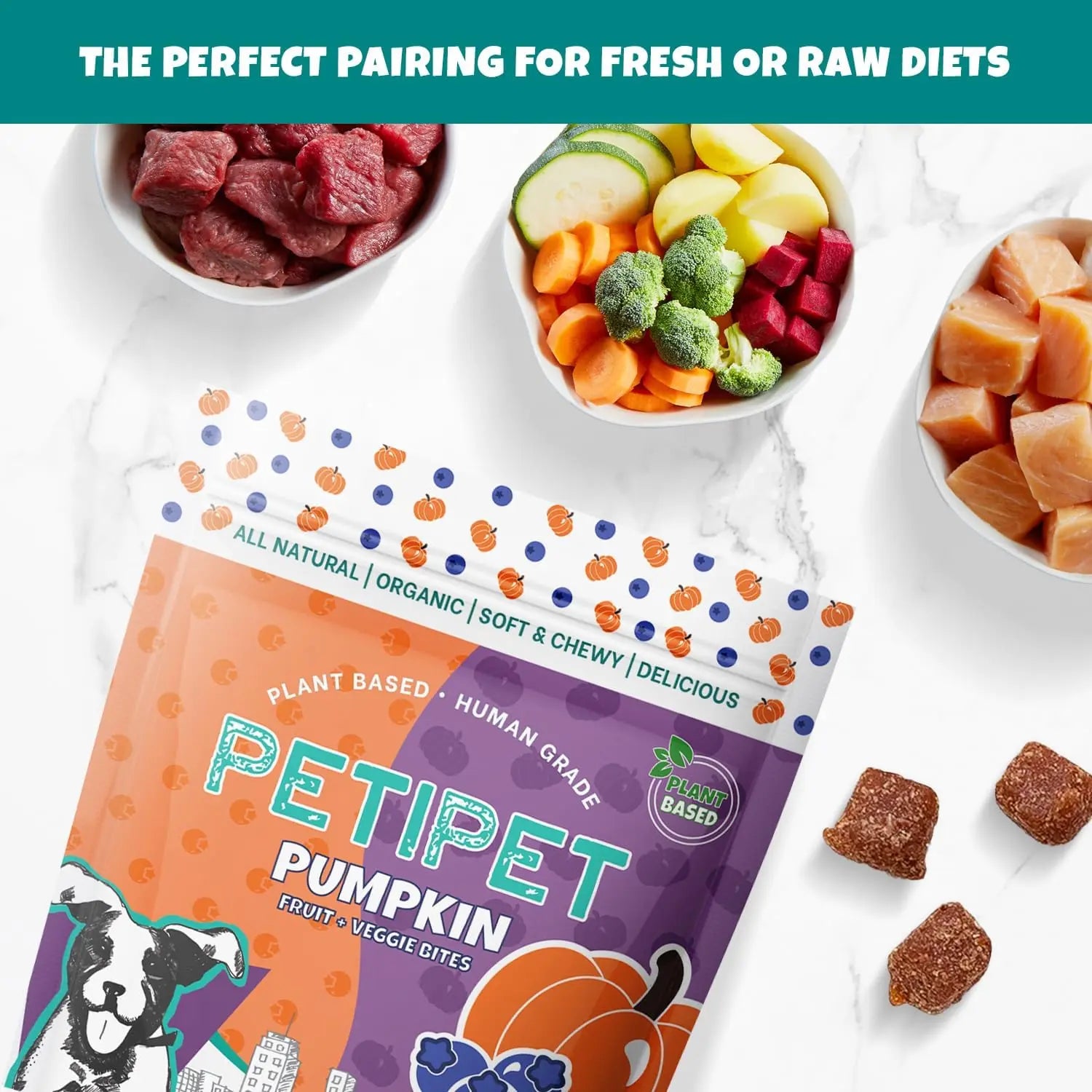 Top-down view of PETIPET Pumpkin Fruit + Veggie Bites Gluten-Free Adult Soft & Chewy Dog Treats 5oz on marble, surrounded by small bowls of raw meat, fruits, and veggies. Perfect with fresh or raw diets—made with human-grade ingredients.