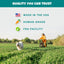 A woman rides a bicycle in a grassy field while a happy white dog runs ahead. Text reads: PETIPET Pumpkin Fruit + Veggie Bites—Gluten-Free, Human-Grade, Vegan Dog Treats, Made in the USA with Premium Ingredients.