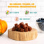 A pile of chewy brown treats rests on a wooden board, near a pumpkin and blueberries. Text reads: No grains, fillers, or artificial preservatives. PETIPET Pumpkin Fruit + Veggie Bites—Gluten-Free Vegan Dog Treats you can trust.