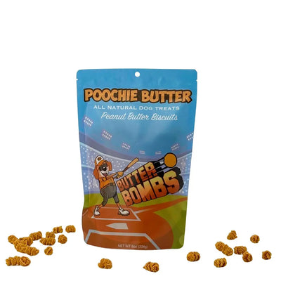 A blue pouch labeled Poochie Butter Peanut Butter Crunchy Dog Treats 8oz by Poochie Butter features a baseball-themed cartoon dog, “Butter Bombs” text, and is surrounded by crunchy dog treats on a white background.